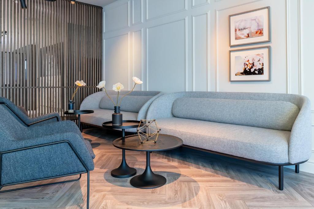 a living room with a blue couch and two tables at Pillows City Hotel Brussels Centre in Brussels