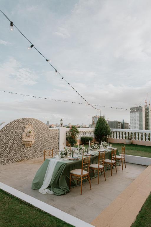 a table with a green tablecloth and chairs on a patio at Sta Barbara Residence Hotel in Cebu City