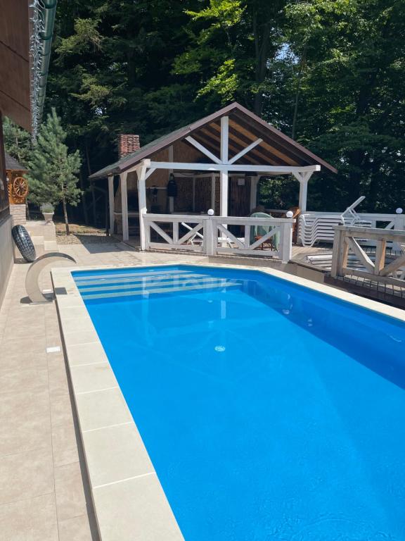 a blue swimming pool with a gazebo at Chalet Mlyn in Migovo