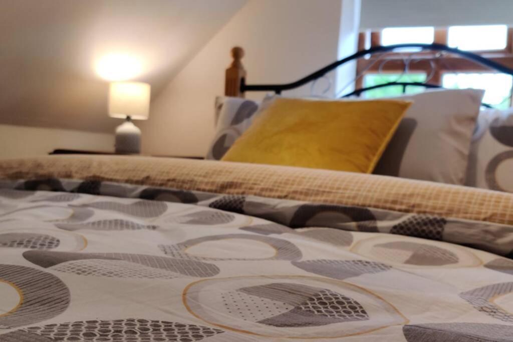 un letto con un cuscino giallo sopra di Luxury 'Cois Abhainn' Self Catering Apartment a Foxford
