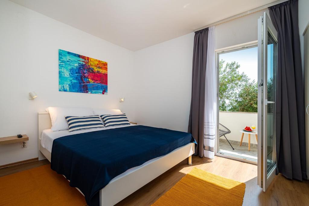 a bedroom with a bed and a large window at la More Apartments in Borovići