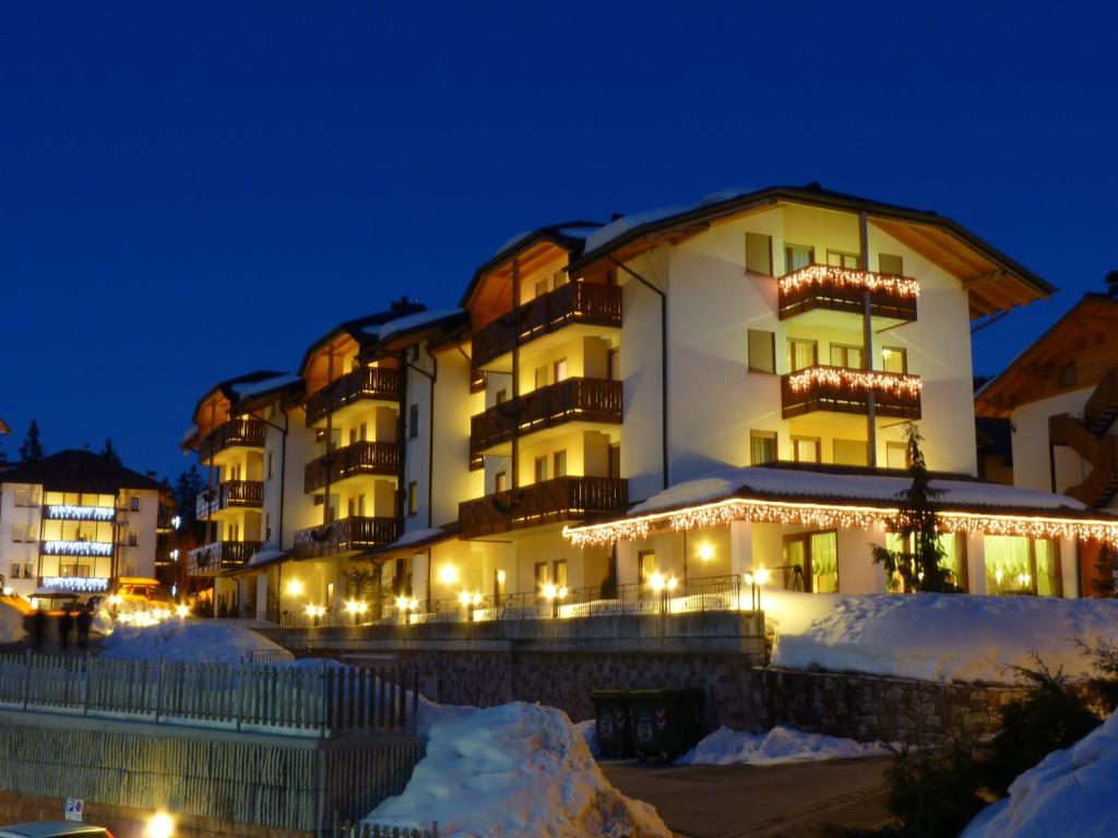 a hotel in the snow at night at Residence Alba Nova in Andalo