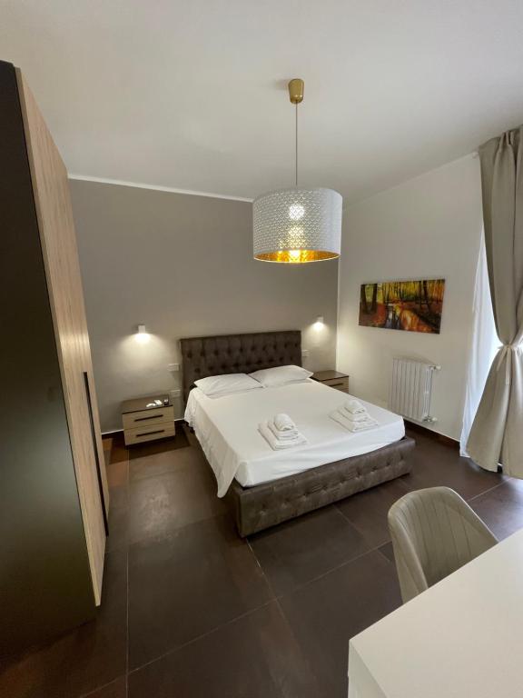 Un dormitorio con una gran cama blanca y una mesa en Relais Petruzzelli en Bari
