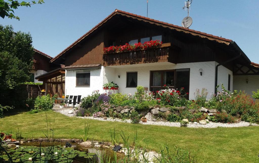 uma casa com uma varanda com flores em Gästehaus Walter em Eisenberg