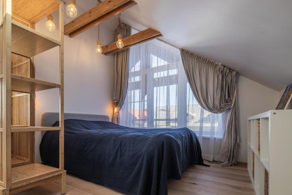 a bedroom with a bunk bed and a large window at Nida Urbas Hill Apartments in Nida