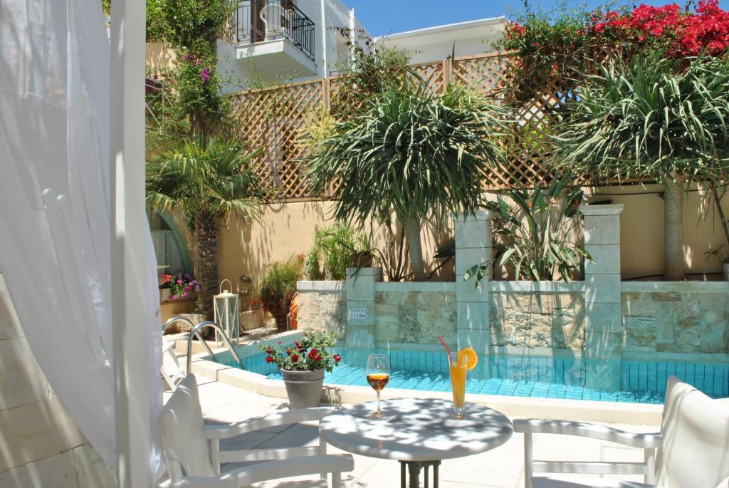 a patio with a table and chairs and a pool at Mythos Suites Boutique Hotel in Rethymno