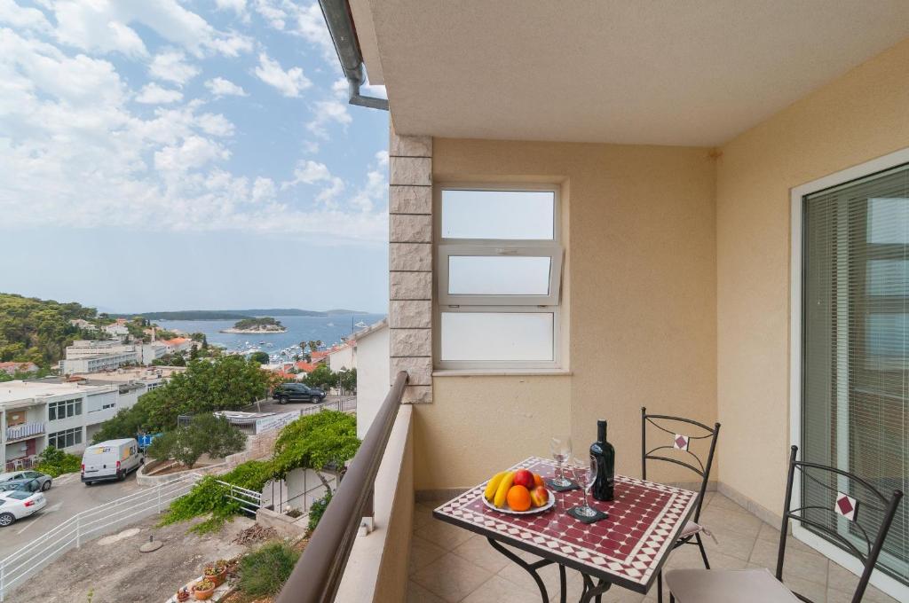 Un balcón con una mesa con fruta. en Apartments Molo Mare, en Hvar