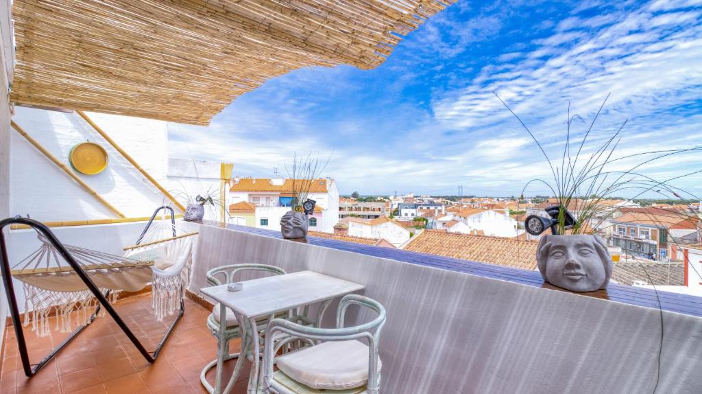 Un patio con una mesa y sillas en un balcón. en Villa Center - Alojamento Local, en Grândola