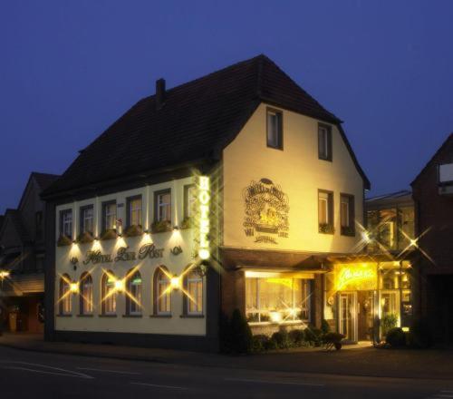 a white building with lights on the side of it at Hotel zur Post in Wettringen