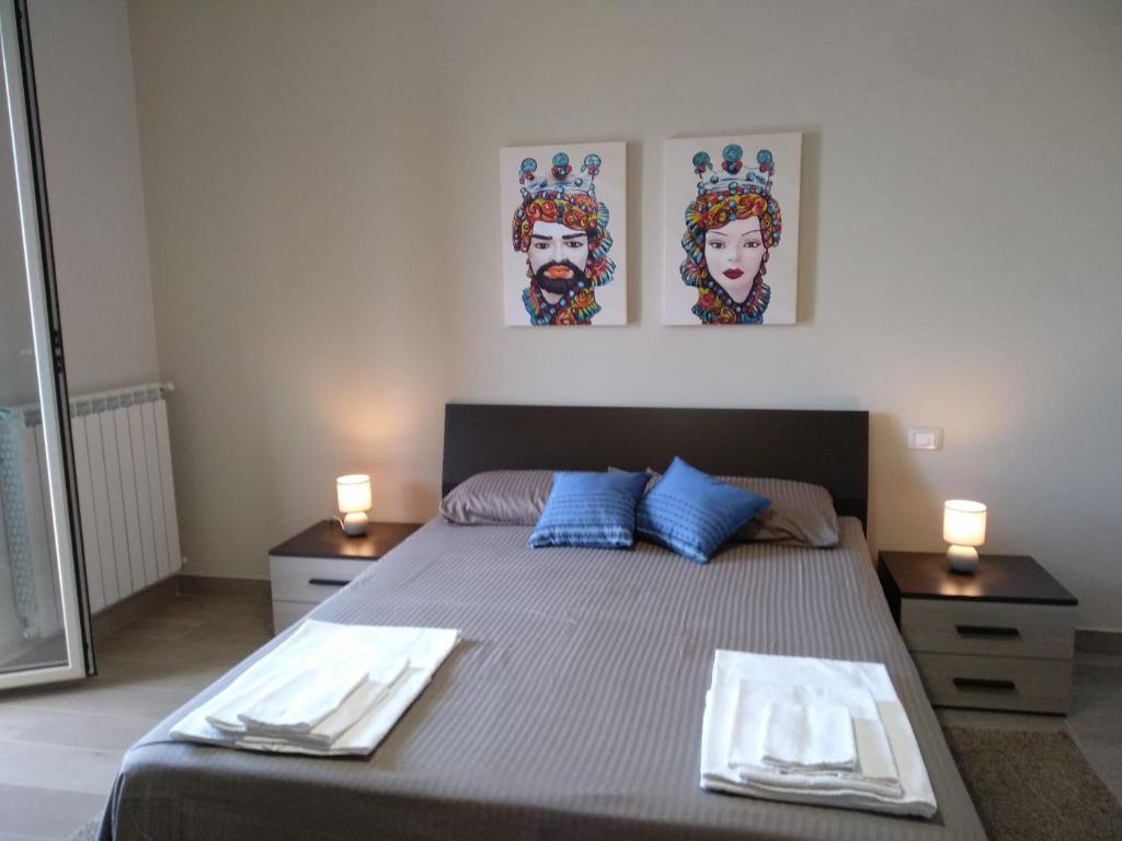 een slaapkamer met een bed met twee borden erop bij Casa del Bosco in Milo