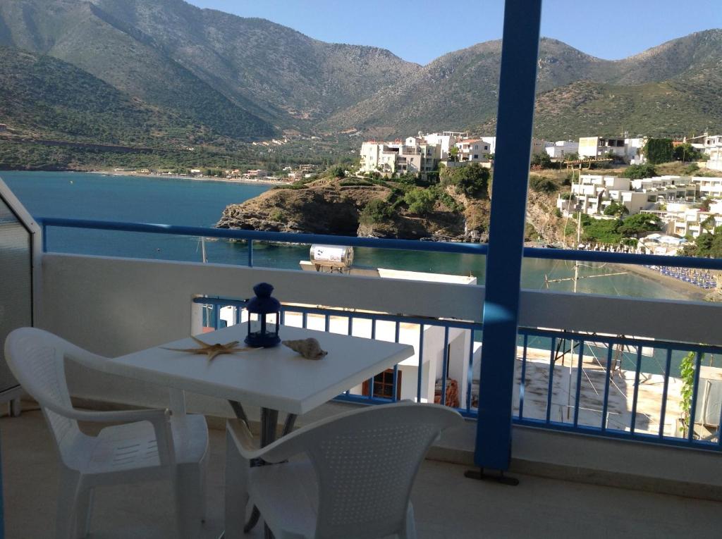 un tavolo e sedie su un balcone con vista sull'oceano di Ikonomakis Apartments a Balíon