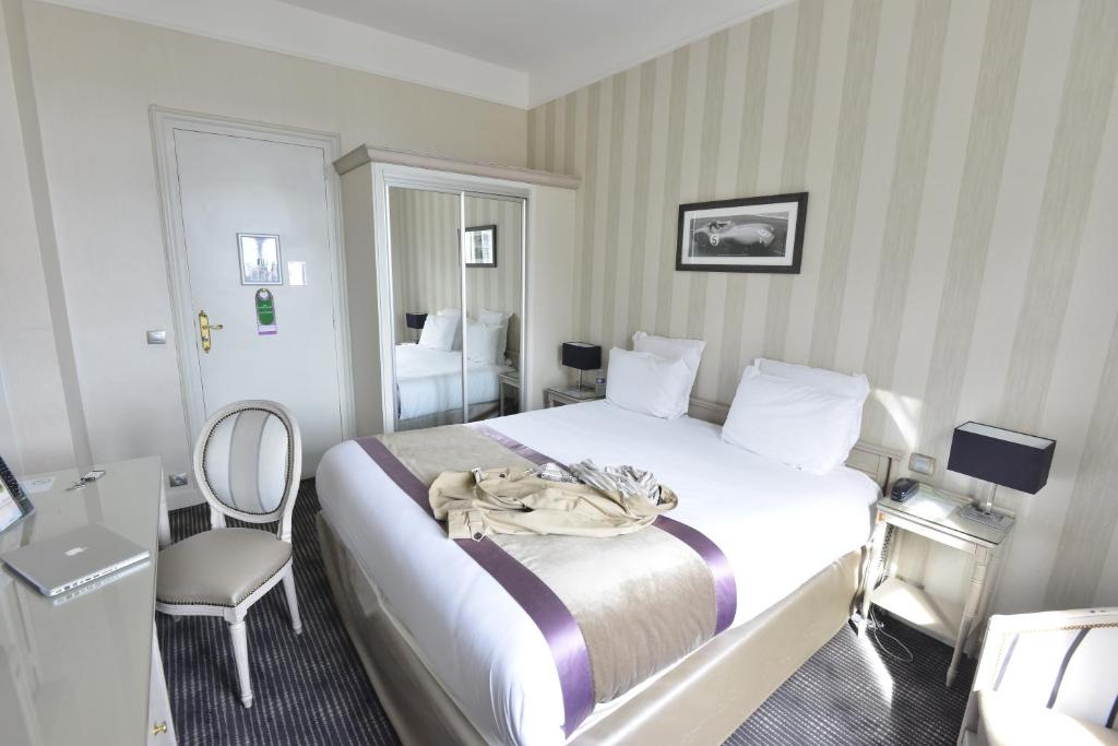 a hotel room with a bed and a chair at Hôtel Concordia Le Mans Centre Gare in Le Mans