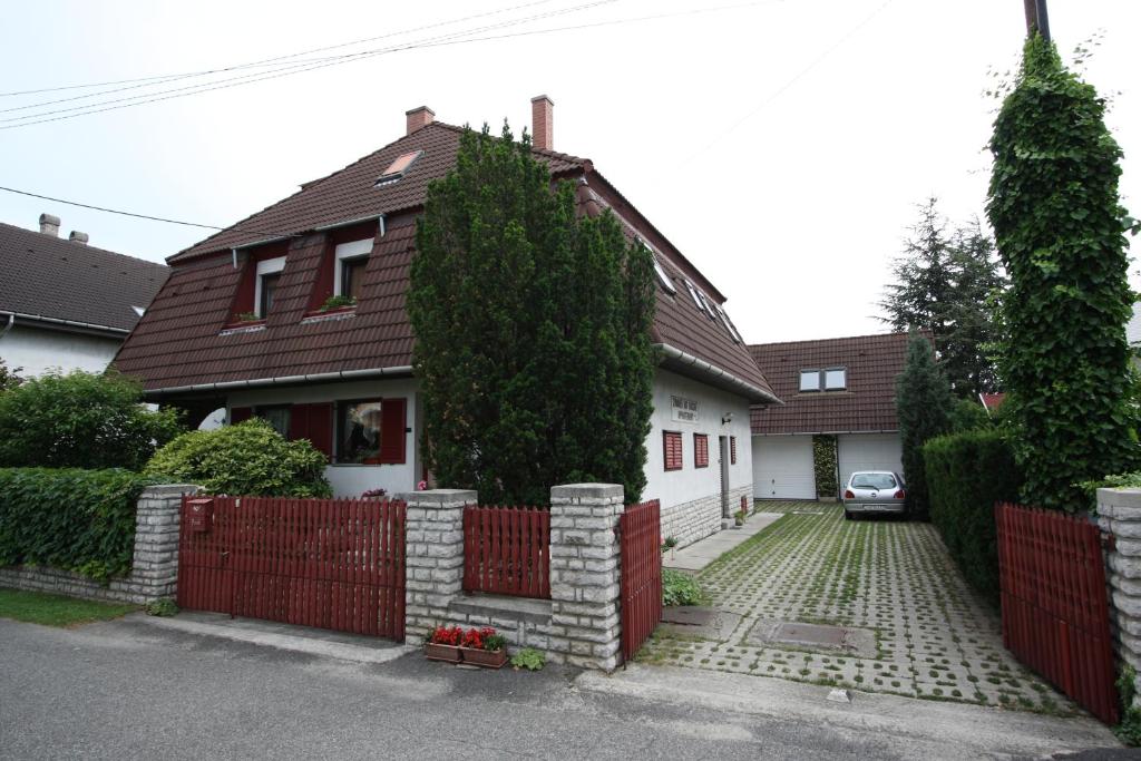 a house with a red fence in front of it at Füvesi Vendégház in Balatonfüred