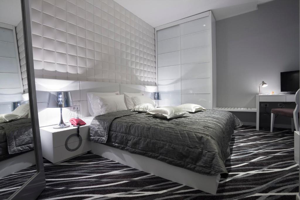 a bedroom with a large bed and a mirror at New Belgrade Garni Hotel in Belgrade