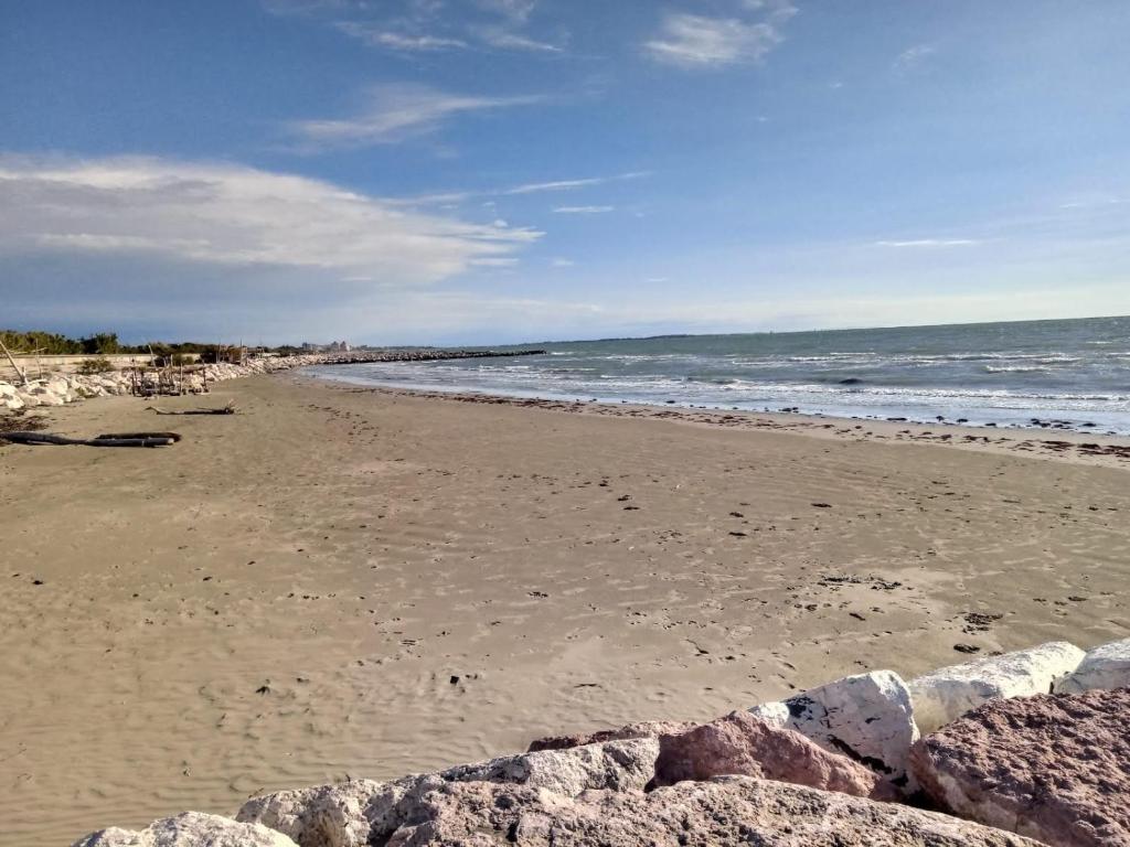 uma praia arenosa com rochas e o oceano em Casa Mary venezia lido em Lido di Venezia