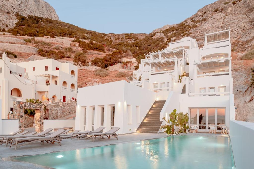 a hotel with a swimming pool in front of white buildings at Mon Signor in Kamari