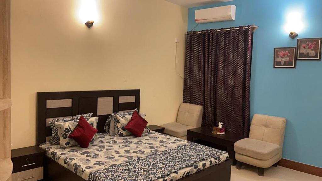 卡拉奇的住宿－Hotel Executive Lodge，一间卧室配有一张床和一把椅子