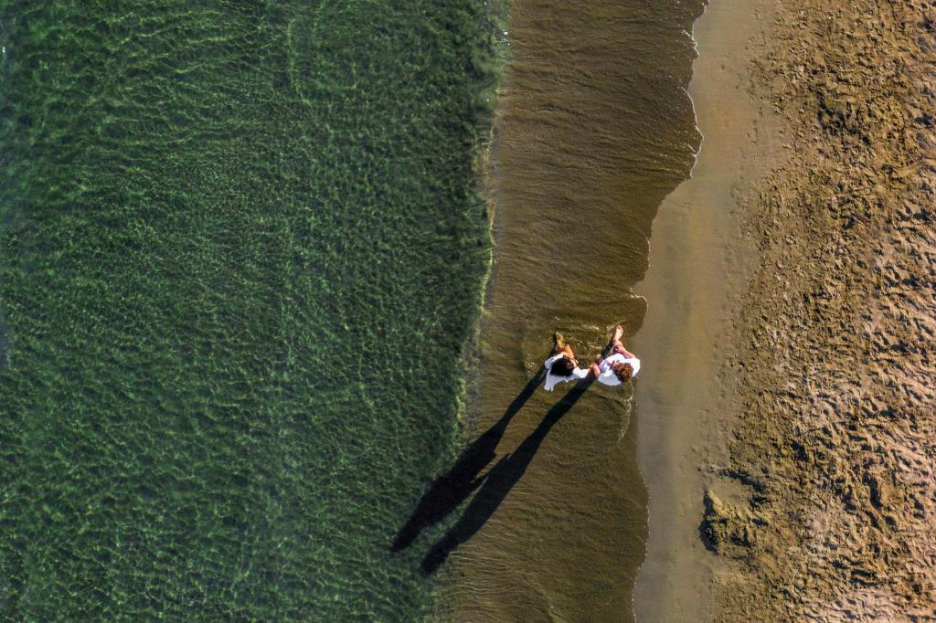 two people in a boat in the water on the beach at St Raphael Resort in Limassol