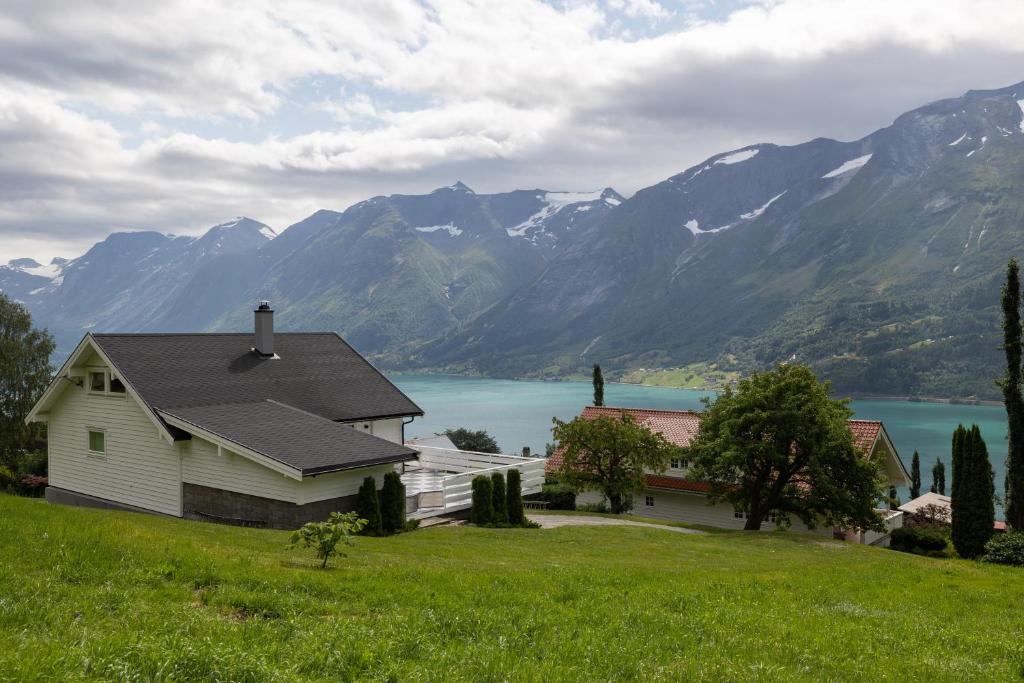 a house with a view of a lake and mountains at Flotunet - Jørnhuset in Stryn