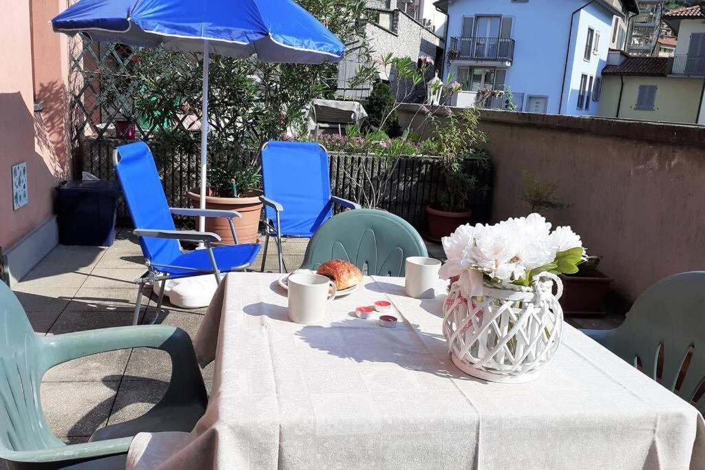 een tafel met een vaas van bloemen en stoelen bij Feel at Home - CASA LOREDANA in Lovere