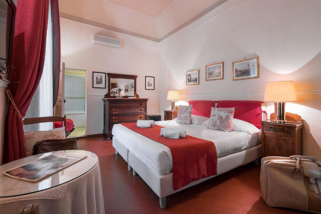 a bedroom with a large bed with a red blanket at Villa Ape Rosa Relais in Florence
