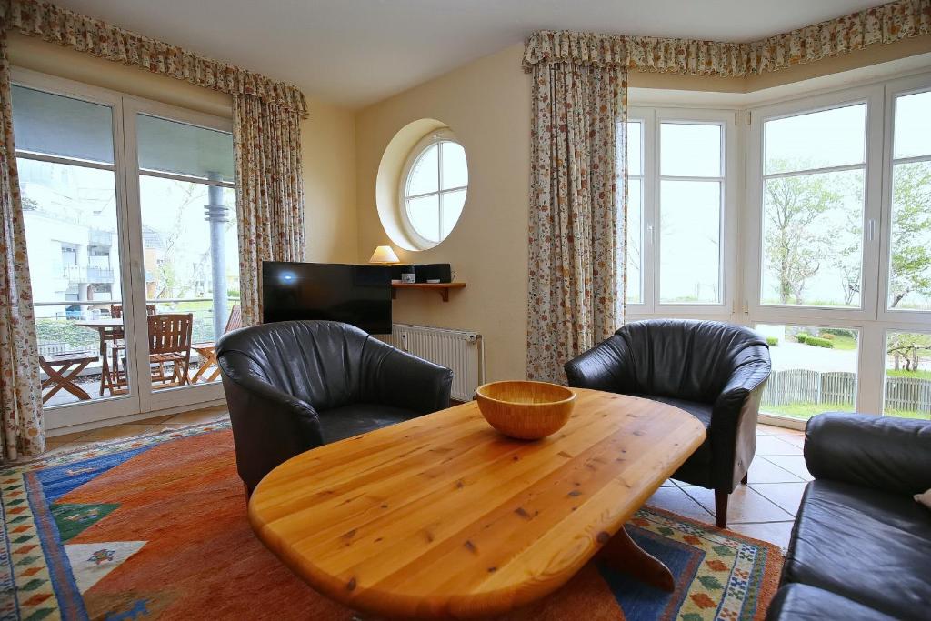 a living room with a wooden table and chairs at Dünenblick Wohnung 46 in Boltenhagen