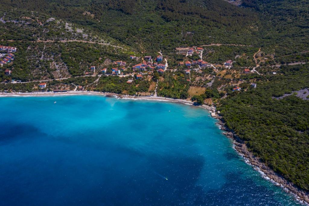 una vista aérea de una playa de agua azul en Apartments and Rooms YASMIN, en Miholašćica