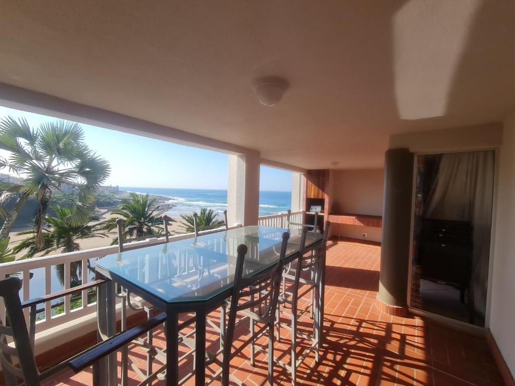 a balcony with a glass table and a view of the beach at Laguna La Crete 94 in Margate