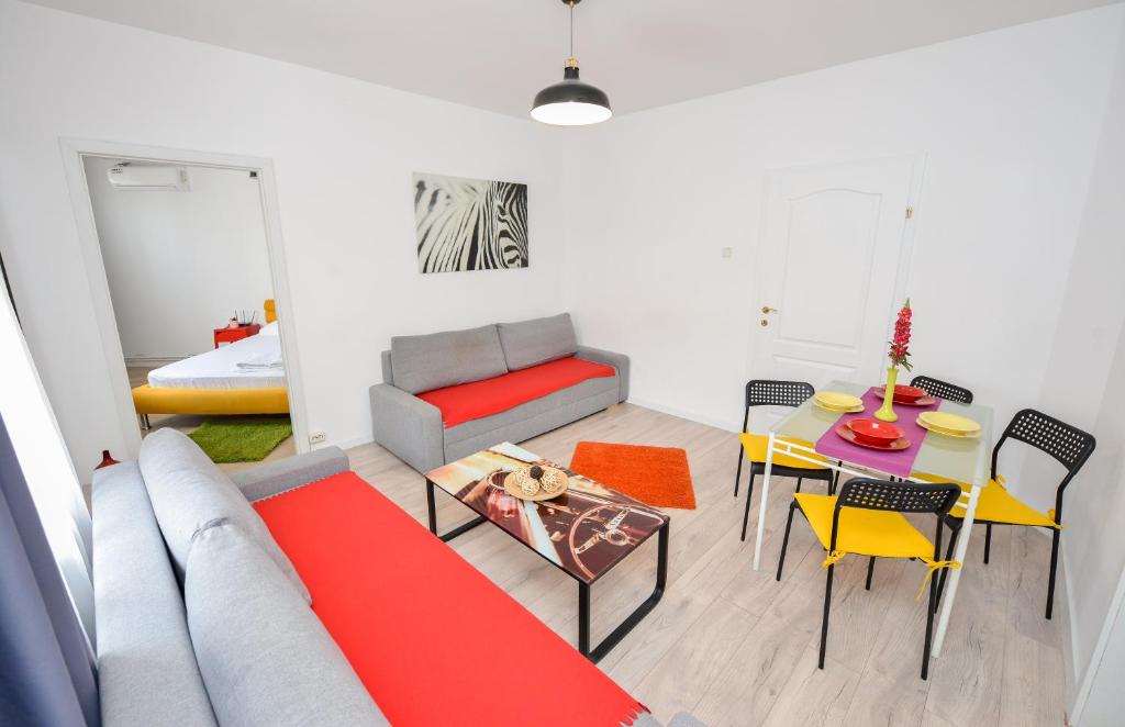 sala de estar con sofá, mesa y sillas en Bucharest Nightlife Apartments, en Bucarest