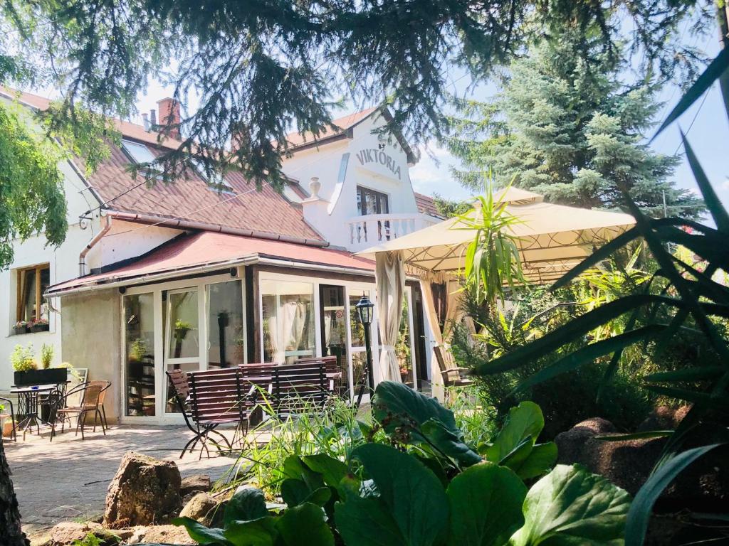 een huis met een veranda en een patio bij Hotel Viktória in Balatonalmádi