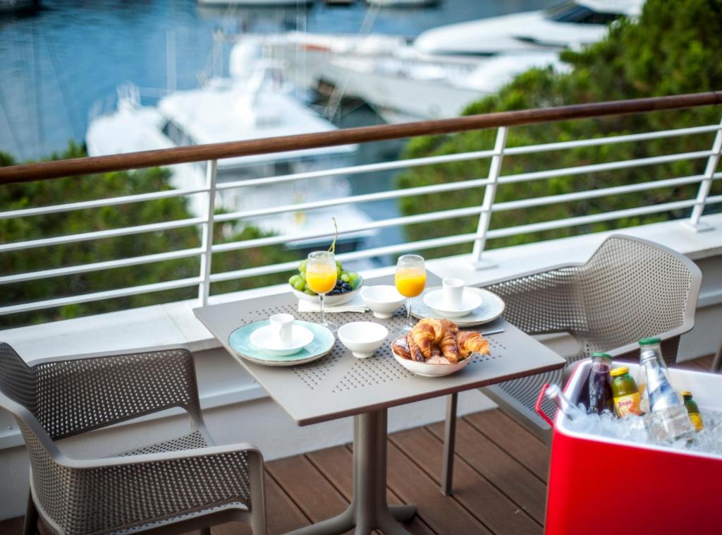- une table avec de la nourriture et des boissons sur un balcon dans l'établissement Boutique Hotel Miramar, à Monte-Carlo