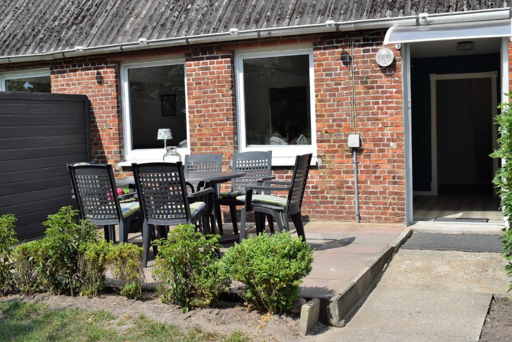 a patio with chairs and a table in front of a brick building at Ferienwohnung Louise in Risum-Lindholm