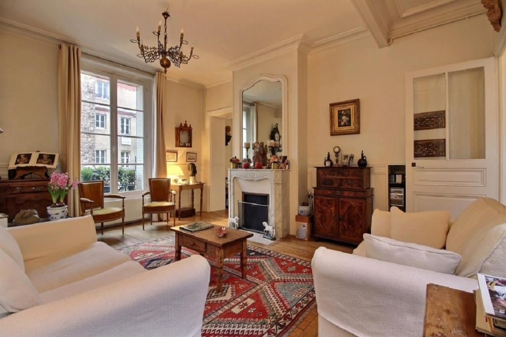 Elle comprend un salon doté d'un mobilier blanc et d'une cheminée. dans l'établissement 207535 - Appartement 4 personnes Champ de Mars, à Paris