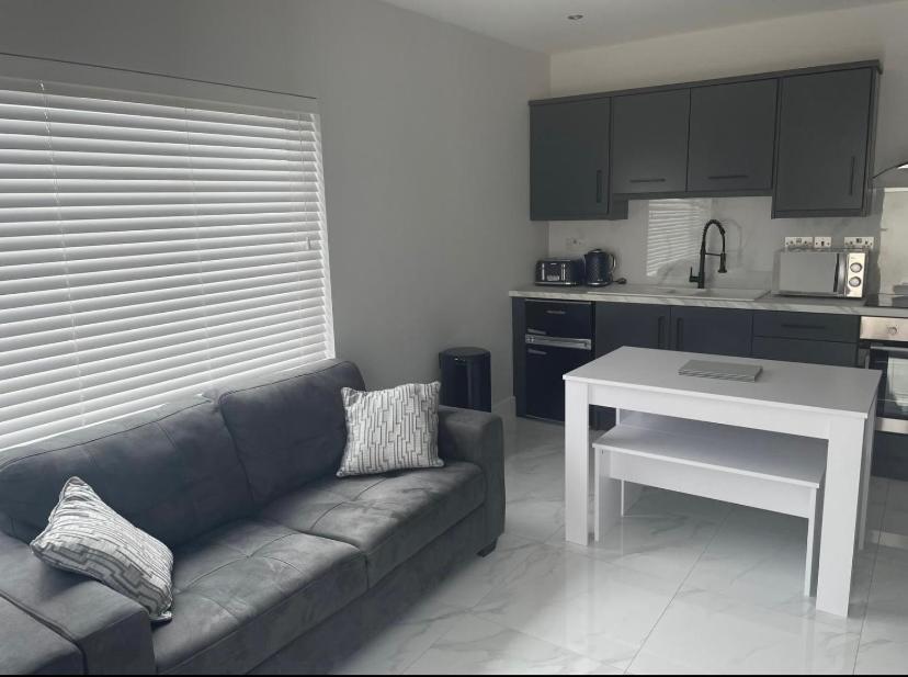 a living room with a couch and a white table at Apt 3, Lisvarna House in Buncrana
