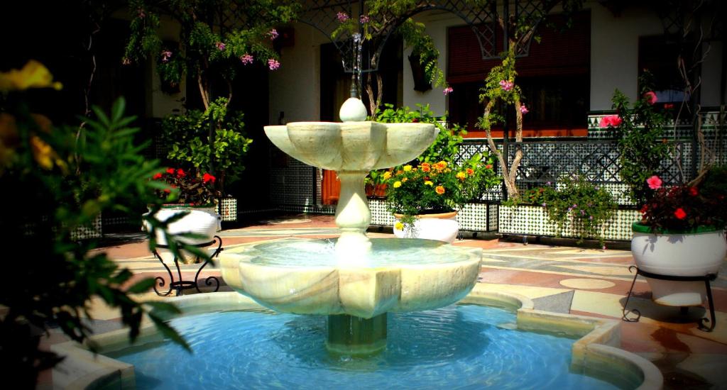 une fontaine au milieu d'une cour fleurie dans l'établissement Estudio con encanto en la Carihuela, à Torremolinos