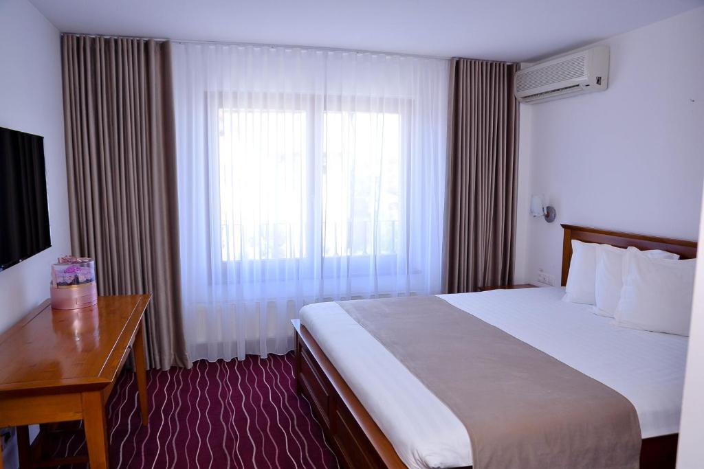 a hotel room with a large bed and a window at Boutique Damiani in Sibiu