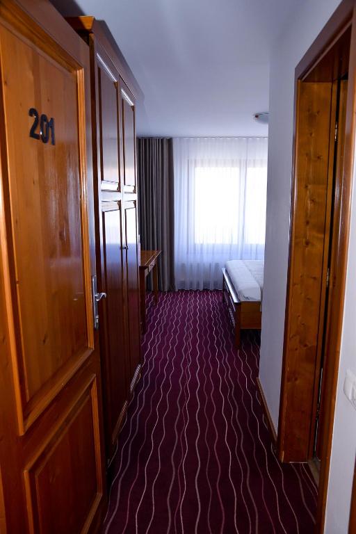 a room with a door and a bed and a window at Boutique Damiani in Sibiu