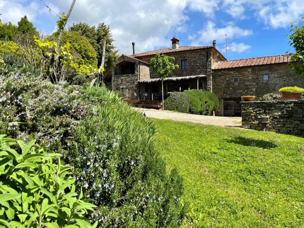 uma antiga casa de pedra com um jardim em frente em Locanda Del Viandante B&B em Anghiari