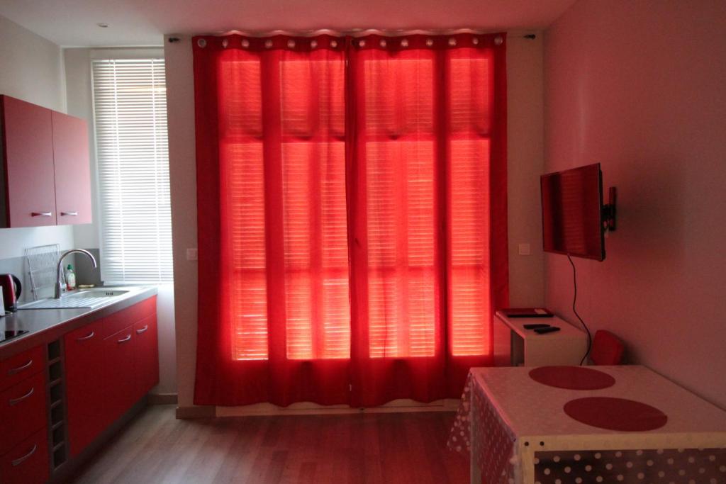 - une cuisine rouge avec des rideaux rouges dans l'établissement Red studio Buffa, à Nice