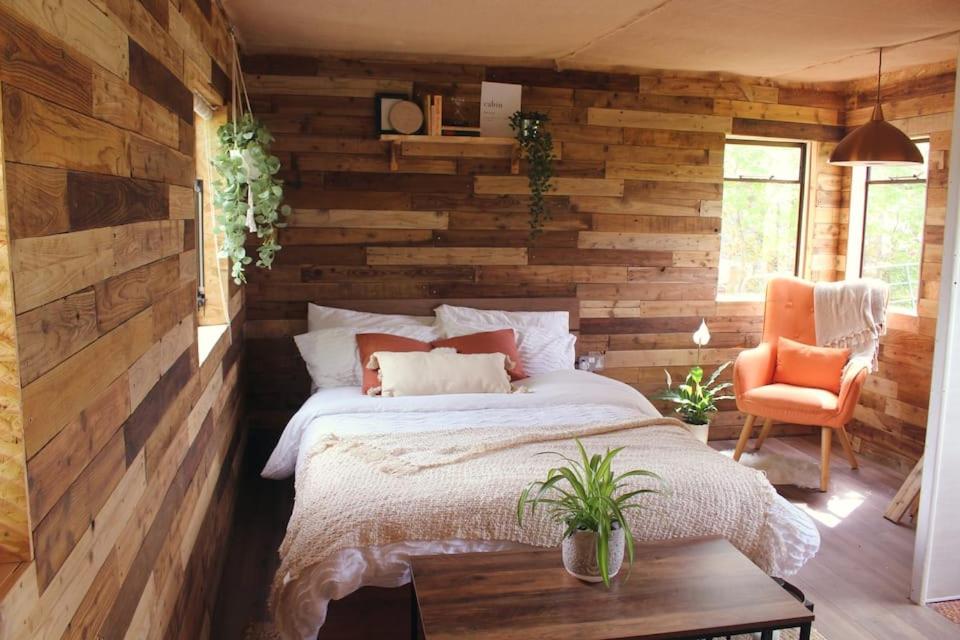 a bedroom with a bed and a wooden wall at The Cabin Project in Portglenone