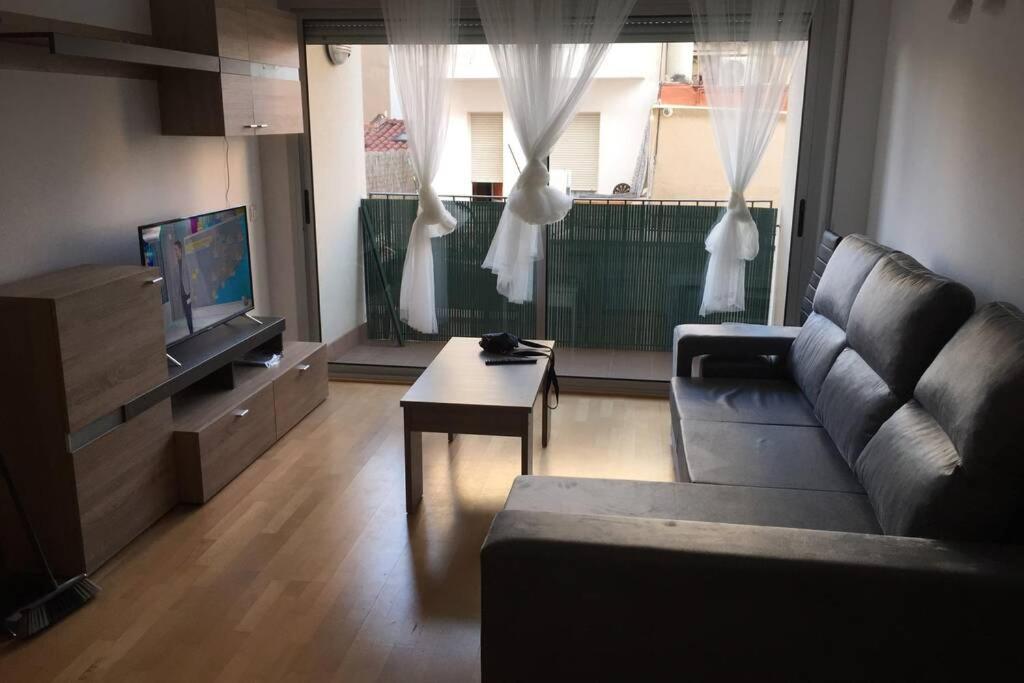 uma sala de estar com um sofá e uma televisão em APARTAMENTO NUEVA CONSTRUCCIÓN EN CENTRO CALELLA em Calella