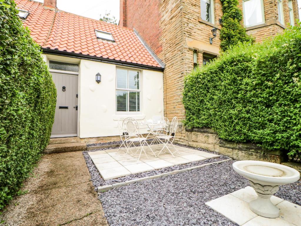 un patio con un aseo blanco y un edificio en 22A Taylors Cottage en Whitley Bay