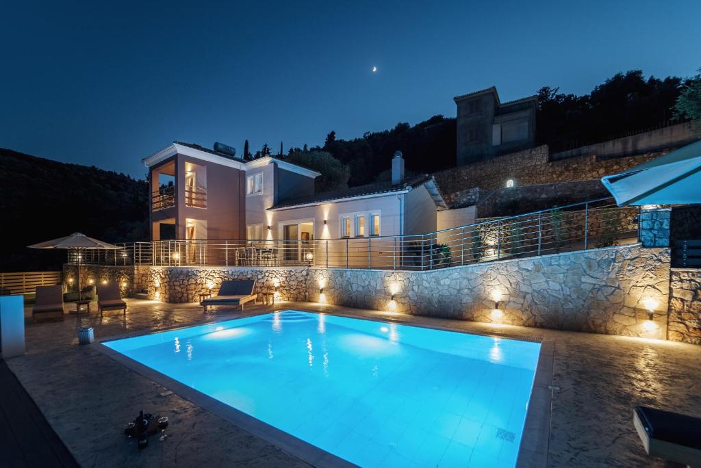 a swimming pool in front of a house at night at Koumaries Villas in Lygia