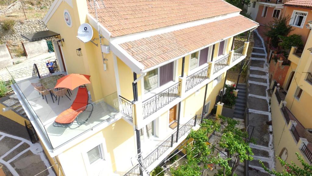 an overhead view of a yellow building with an orange umbrella at Lulumba Luxury House in Lákones