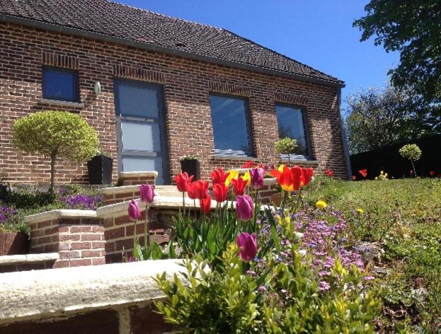 a brick house with flowers in front of it at Chez nous. in Couvin