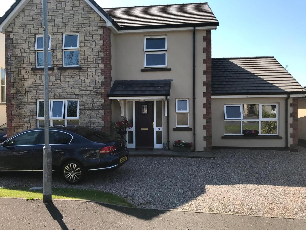 a house with a car parked in front of it at The perfect rest place in Omagh