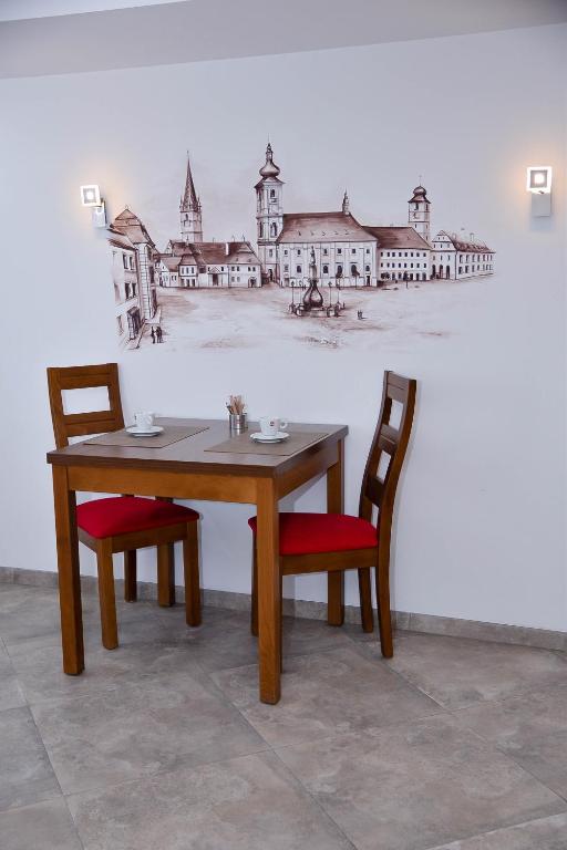 a table with two chairs and a painting on a wall at Boutique Damiani in Sibiu