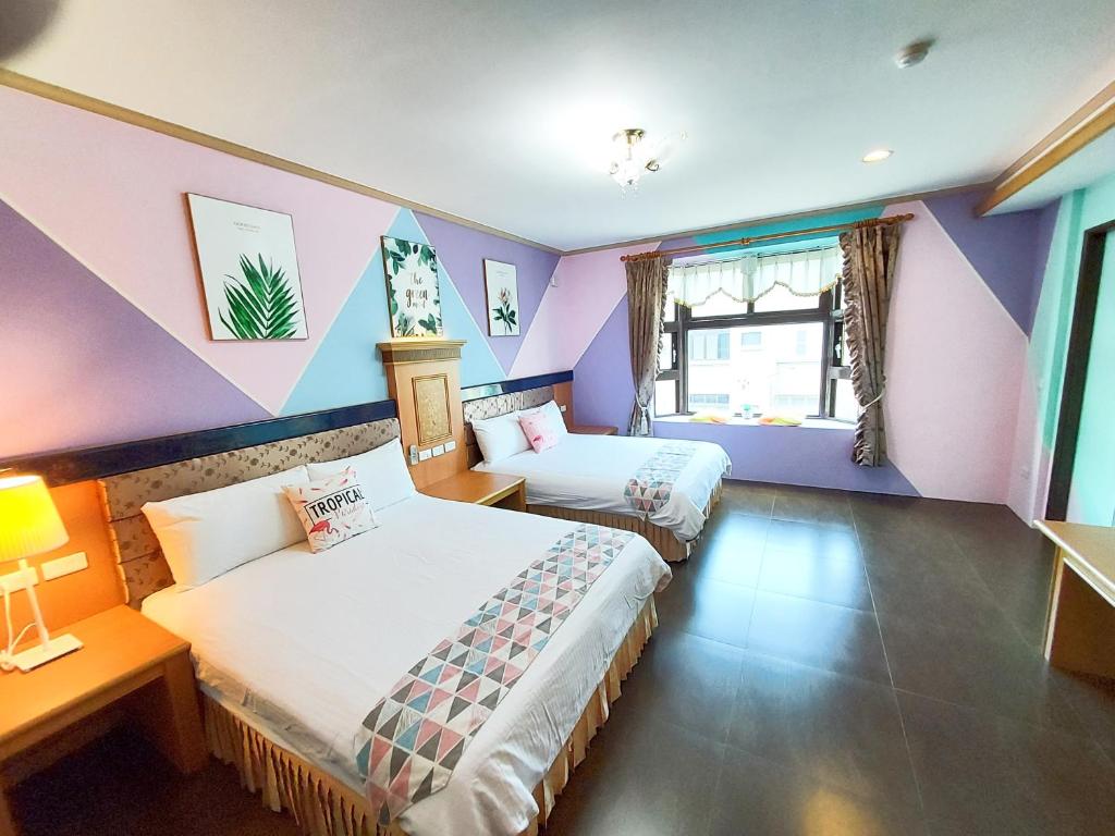 two beds in a room with purple walls at 恆春古城親子民宿 in Hengchun South Gate