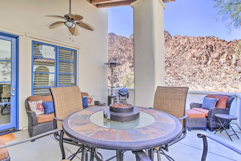un patio con mesa, sillas y montañas en Desert Views and Pool Access Home in La Quinta!, en La Quinta