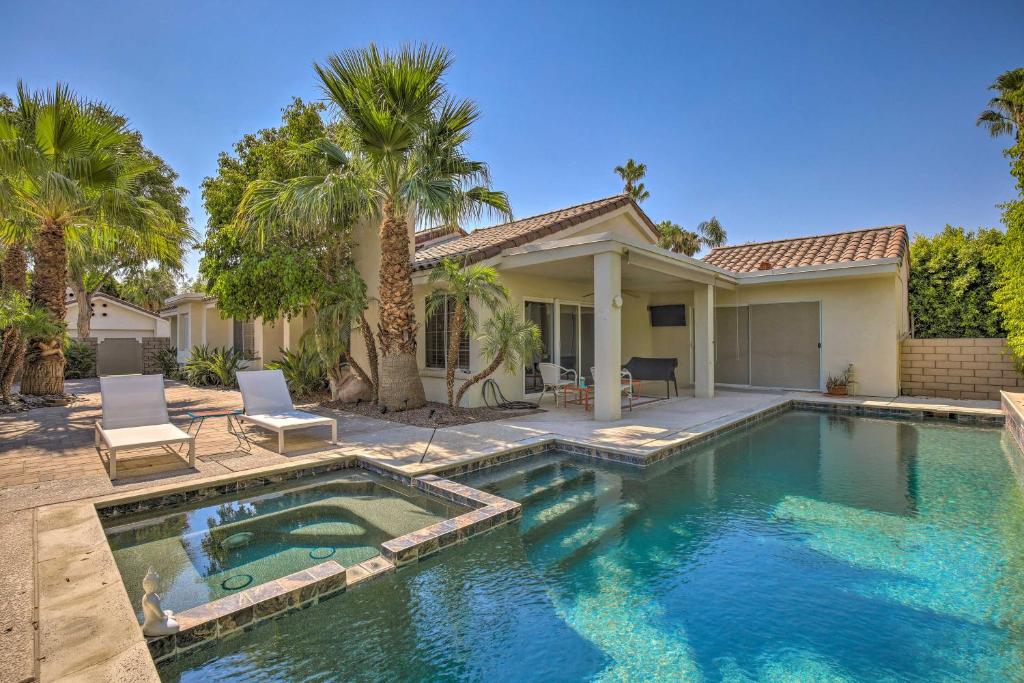 a swimming pool in front of a house with palm trees at Luxe Palm Desert Retreat with Private Outdoor Oasis! in Palm Desert